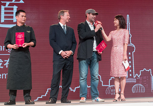 Ultraviolet chef Paul Pairet (second from right) and Tan Shiye, chef of T'ang Court (left), accept awards at the launching ceremony of the Shanghai Michelin Guide for 2018 on Wednesday. Their restaurants were the only ones in the city given three stars. Gao Erqiang / China Daily
