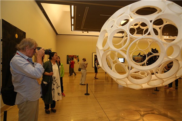 Visitors attend the ongoing Beijing International Art Biennale that features more than 600 paintings, sculptures and installations from more than 100 countries.(Photo provided to China Daily)