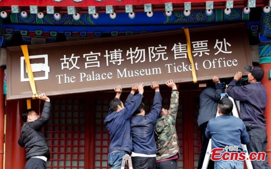 Staff members of the Palace Museum remove the ticket office sign in Beijing, Oct. 10, 2017, as all ticket sales go online. The Palace Museum sets a daily visitor cap of 80,000 and set a record by selling all tickets online in about 90 minutes on Oct. 2. It will celebrate the 92nd anniversary of its founding. (Photo: China News Service/Du Yang)