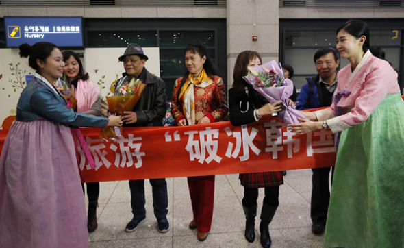 Staff workers at South Korea's Incheon International Airport welcome Chinese tourists on Saturday. (Photo/China Daily)