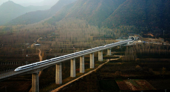 A bullet train emerges from a tunnel in the Qinling Mountains on Wednesday. (LIU XIAO/XINHUA)