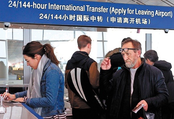 Travelers apply for up to 144-hour visa-free entry at Beijing Capital International Airport on Thursday. The entry also can be used to visit Tianjin and Hebei province. (Zou Hong/China Daily)