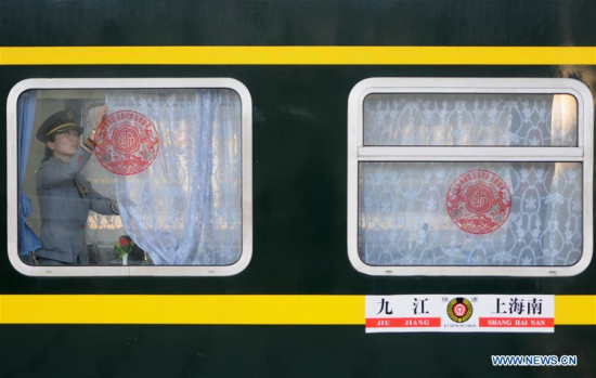 A railway crew member draws the curtain of a train carriage at Jiujiang Railway Station in Jiujiang, east China's Jiangxi Province, March 12, 2018. (Xinhua/Hu Guolin)