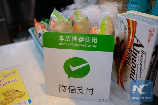 A plate of Wechat Pay is shown at the counter of a store in Bangkok, Thailand, May 5, 2017. It is a common thing in China to take no cash and pay with a smartphone, which is installed with China's Alipay or Wechat apps. (Xinhua/Li Mangmang)