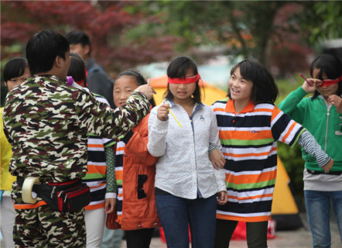 Volunteers play games with children to help them relax after the earthquake in Lushan county, Ya'an city, Sichuan province April 24, 2013. Days after the quake, some have not recovered from the horror of the incident and psychological experts and volunteers organized activities to help. [Photo by Zhang Xiaoli/Asianewsphoto]
