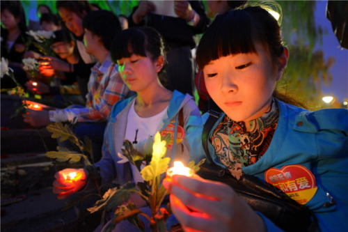 Volunteers from a hospital in Lanzhou city, Gansu province pray for the earthquake victims in Ya'an, Sichuan province, April 22, 2013. [Photo by Pei Qiang/Asianewsphoto]