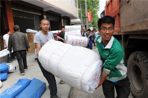 Volunteers carry relief materials in Longmen township, Ya'an city, April 23, 2013. [Photo/Xinhua]