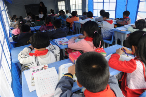 Daping Central Primary School students are back in class in a makeshift classroom in quake-hit Tianquan county, Southwest China's Sichuan province, April 25, 2013. [Photo by Mo Xiao/Asianewsphoto]