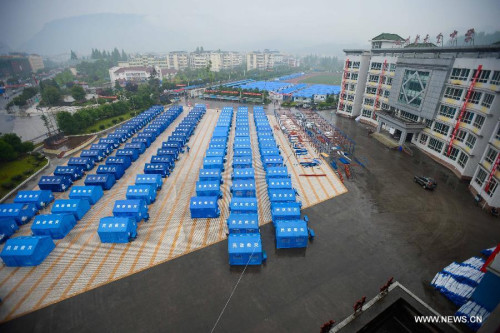 Photo taken on April 29, 2013 shows temporarily-erected dormitories outside Tianquan Middle School in Tianquan County, southwest China's Sichuan Province. The earthquake-hit region in Sichuan Province received a rainfall on April 29, but the rain did not affect those students who have resumed their classes in fabricated houses. (Xinhua/Li Qiaoqiao) 