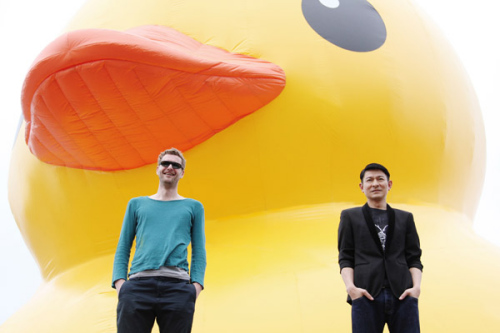 Hong Kong actor Andy Lau and Dutch artist Florentijn Hofmans (L) pose in front of Hofmans�� installation Rubber Duck in Hong Kong, April 29, 2013. The Rubber Duck knows no frontiers, it doesn't discriminate people and doesn't have a political connotation, according to the artist's website (www.florentijnhofman.nl). [Photo/Icpress]  
