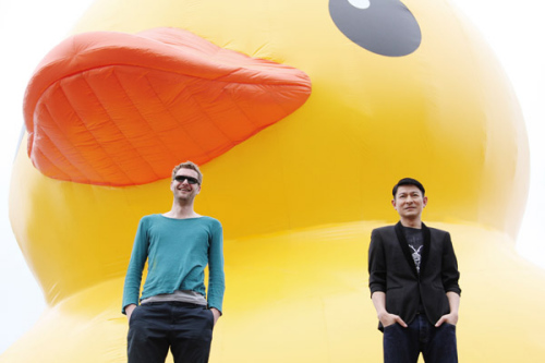 Hong Kong actor Andy Lau and Dutch artist Florentijn Hofmans (L) pose in front of Hofmans installation Rubber Duck in Hong Kong, April 29, 2013. The Rubber Duck knows no frontiers, it doesn't discriminate people and doesn't have a political connotation, according to the artist's website (www.florentijnhofman.nl). [Photo/Icpress]  