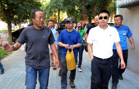 Zhang Jingchuan (middle), the only survivor of a four-member Chinese amateur mountaineering team following an Taliban terrorist attack in northern Pakistan on Sunday, arrives in Urumqi, Northwest China's Xinjiang autonomous region, June 25, 2013. He will take another flight on Wednesday to his home in Kunming, Southwest China's Yunnan province. [Photo by Zhang Wande/Asianewsphoto]