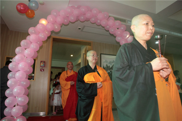 Buddhist masters attend the first formal Buddhism wedding in Xiamen city, Fujian province on July 6, 2013. This kind of ceremony is still new in the Chinese mainland while it appeared in Taiwan fifty years ago and has gradually become popular. Compared with ordinary weddings, it adds some Buddhist procedures and the whole process lasts for about 30 minutes. [Photo by Mo Feng/Asianewsphoto]