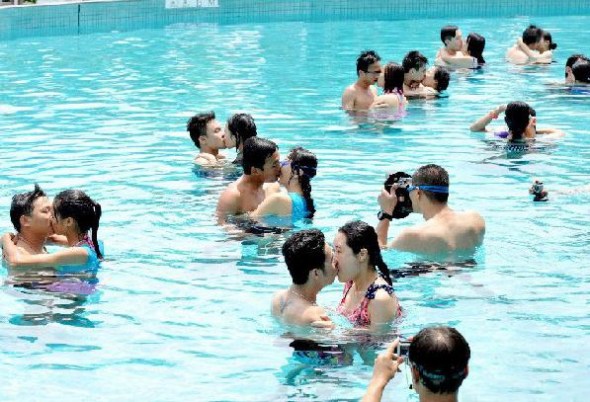 Couples prepare for an underwater kissing contest held in Guangzhou, Guangdong province on July 6, 2013. Ten couples took part with one pair winning for lasting 57 seconds. July 6 is International Kissing Day. [Photo/chinanews.com]
