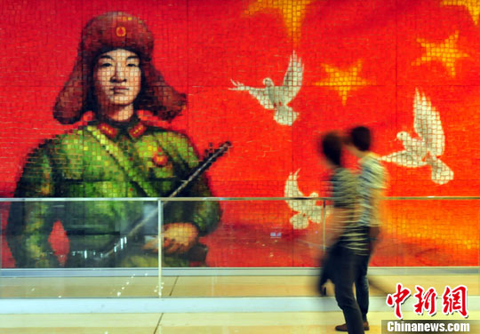 A massive painting on toast featuring Lei Feng, the nation´s most famous Good Samaritan, is put on display in a commercial plaza in Fuzhou, capital of East China's Fujian Province Thursday, July 11, 2013. The painting made with 2,500 slices of toast is created by a professional art team. (Photo: CNS/Wang Dongming)
