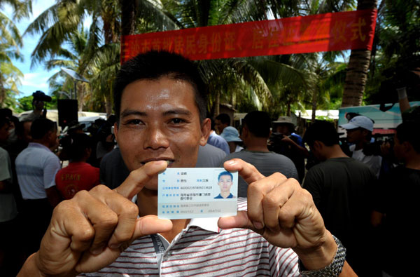 Liang Feng receives his residence permit card in Sansha city, July 17, 2013. [Photo/Xinhua]