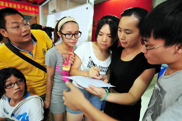 College students check the list of prospective employers while training to become certificated domestic helpers in Fuzhou, Fujian province, on July 16, 2013. [Photo by Zhang Bin/Asianewsphoto]