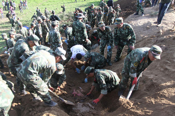 Soldiers search for survivors in Yongguang village, Minxian county, July 22, 2013. Eighty-seven people in the city of Dingxi and two in the neighboring city of Longnan has been confirmed killed in a 6.6-magnitude quake that jolted the border of Minxian and Zhangxian counties at 7:45 am in Northwest China's Gansu province. Two helicopters and about 3,000 armed police, firefighters, soldiers and local government staffers have been sent to the quake-hit region to help with rescue work. [Photo/Xinhua]