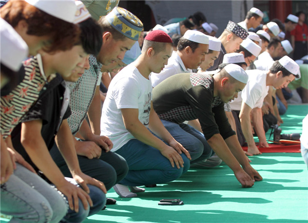 Muslims pray at Niujie Mosque in Beijing on Aug 8, 2013. The three-day festival marks the end of Ramadan, Islam's holy month of fasting.[Zou Hong/Asianewsphoto]