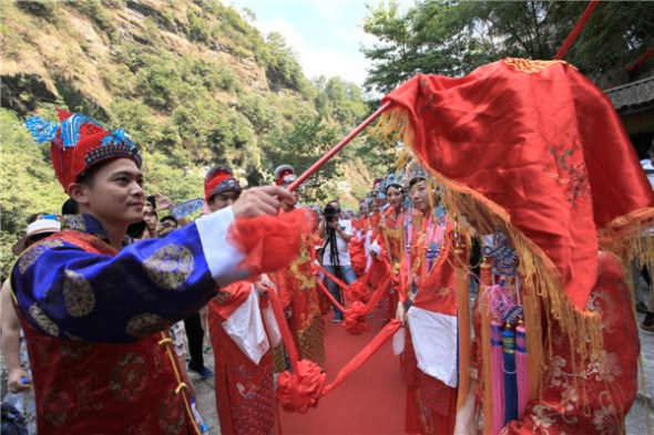 A couple gets married in a traditional Anhui-style ceremony at Huangshan Mountain scenic spot, Aug 13, 2013. [Photo by Shi Guangde/Asianewsphoto]
