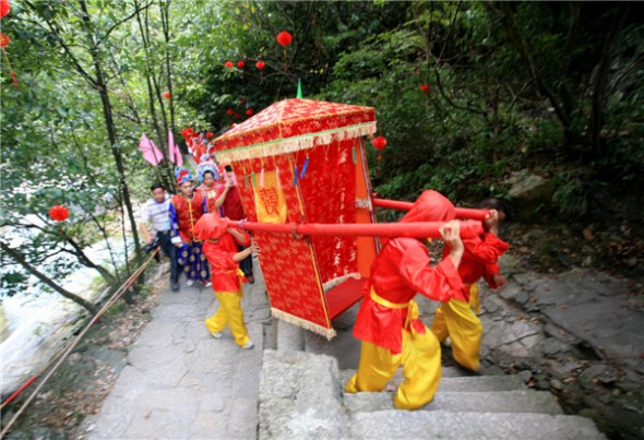 A couple gets married in a traditional Anhui-style ceremony at Huangshan Mountain scenic spot, Aug 13, 2013. [Photo by Shi Guangde/Asianewsphoto]