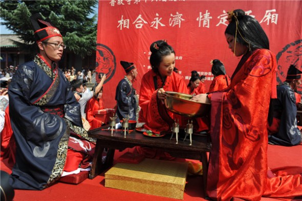 Couples get married in a Han Dynasty (206 BC-AD 220)-style wedding in Yongji, Shanxi, Aug 13, 2013. [Photo by Liu Cheng/Asianewsphoto]