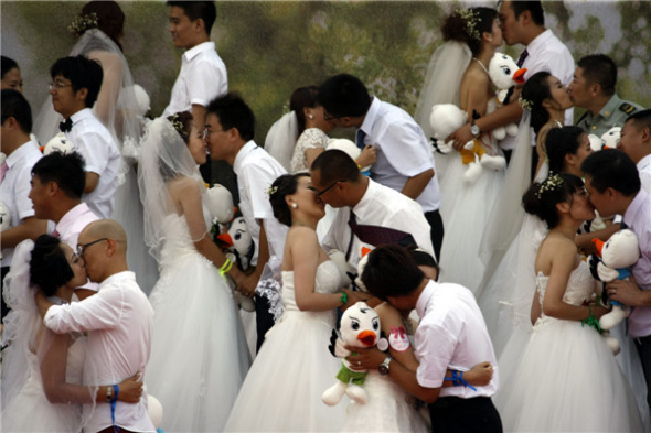 Couples get hitched in a group wedding in Jinzhou, Liaoning province, on Aug 13. [Photo by Chen Hao/Asianewsphoto]