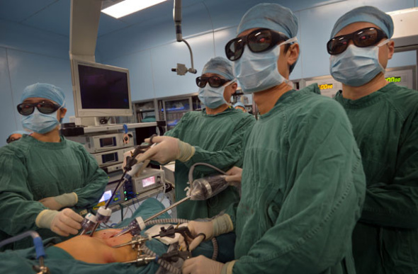 Doctors wearing 3D glasses perform a radical gastric cancer operation at Tongji Hospital in Wuhan, Central China' Hubei province, Aug 22, 2013. [Photo/Asianewsphoto]
