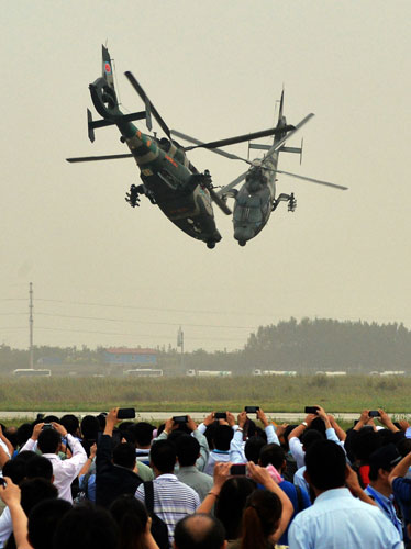 Visitors watch an aerobatic flight at the Second China Helicopter Exposition in the northern city of Tianjin, Sept 5, 2013. The exposition kicked off on Thursday. [Photo/Xinhua]