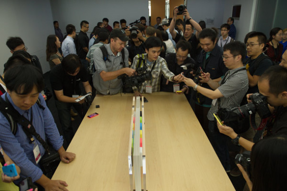 Reporters try to use the new iPhone 5C at a media event in Beijing, on Sept 11, 2013. [Photo by Wei Xiaochen/Asianewsphoto]