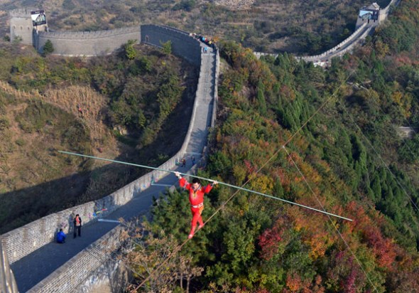 Tightrope walker Adili Wuxor walks on steel wires about 100 meters above the Huangyaguan Great Wall in Ji county, Tianjin, on Oct 17, 2013. [Photo/Xinhua]