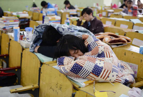 College students wrap themselves in blankets while taking a break from studying in preparation for the 2014 graduate school admission examination in Taiyuan, Shanxi province, Oct 29, 2013. The annual exam, which gives many college students another chance to study in a better school, is usually scheduled in January. [Photo by Liu Jiang/Asianewsphoto]