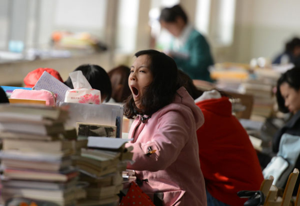 A college student yawns after a long study session in Taiyuan, Shanxi province, Oct 29, 2013. [Photo by Liu Jiang/Asianewsphoto]
