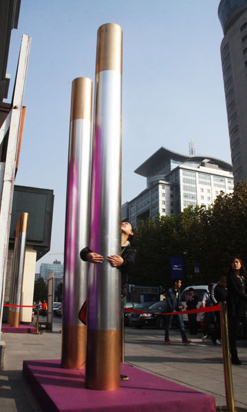 Four 5-meter sticks, Ruyi Jingu Bang, were placed in front of a store to mark the upcoming Singles Day, which is Nov 11, in Jinan, East China's Shandong province, Nov 6. [Photo by Zheng Tao/Asianewsphoto]
