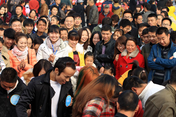 Participants play interactive games to get to know each other at a large matchmaking fair held in Xuchang, Central China's Henan province, Nov 10. [Photo by Niu Yuan/Asianewsphoto]
