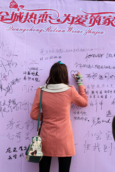 A single woman leaves a message on a wishing wall at a large matchmaking fair held in Xuchang, Central China's Henan province, Nov 10. [Photo by Niu Yuan/Asianewsphoto]