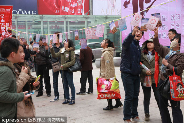Single people and their parents view information about participants at a large matchmaking event held in Shenyang, Northeast China's Liaoning province, Nov 9. The nine-day event includes many themed parties organized for white-collar workers as well as young and middle-aged people. [Photo/icpress.cn]