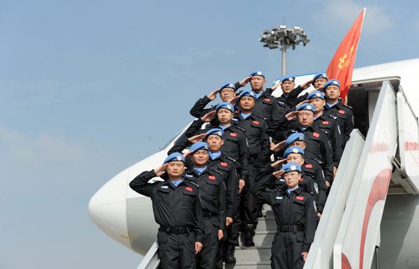 Expedition members salute as they say farewell to the public at Chengdu Shuangliu International Airport, Nov 12, 2013. Fifteen policemen and policewomen from Southwest China's Sichuan province kicked off a one-year peacekeeping mission for the United Nations in South Sudan in a departure ceremony held in Chengdu, capital of Sichuan. The mission team consists of police officers with various specialties including criminal investigation and drug enforcement, covering members ranging from post-60s generation to post-80s. They will go for training in North China's Hebei province and Uganda before heading to South Sudan. This is the second time since 2008 that Sichuan has independently participated in a UN mission. [Photo by He Haiyang/Asianewsphoto]