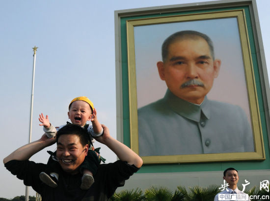 Tourists are in front of a huge Sun Yat-sen portrait displayed on Tian'anmen Square ahead of the three-day May Day holiday in Beijing on April 27, 2014. [Photo: CNR]