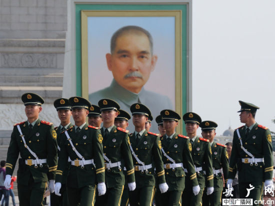Chinese national flag guards walk in front of a huge Sun Yat-sen portrait displayed on Tian'anmen Square ahead of the three-day May Day holiday in Beijing on April 27, 2014. [Photo: CNR]