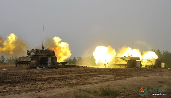 The photo shows that the howitzers are firing. An artillery regiment of the 1st Combined Corps of the Army of the Chinese Peoples Liberation Army (PLA) organized its troops to conduct an actual-troop live-ammunition tactical drill in complex electromagnetic environment on April 27, 2014. (Chinamil.com.cn/Liu Chengzhong)