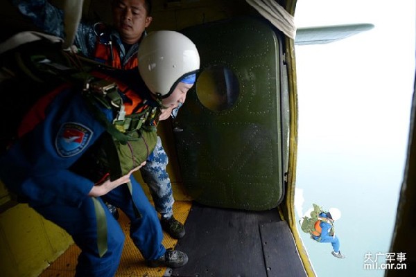 The picture shows a female soldier is about to jump out of the cabin. (mil.cnr.cn/Shen Ling)