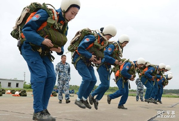 The picture shows that female pilots practice the jump on ground before boarding the plane. (mil.cnr.cn/Shen Ling)