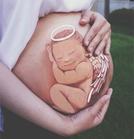 An expectant mother named Luo Qianxi shows her works of art on the stomach featuring her unborn baby. Luo, a painter by profession, has painted pictures on her growing bump to record her pregnancy. [Photo: Chengdu Evening News]
