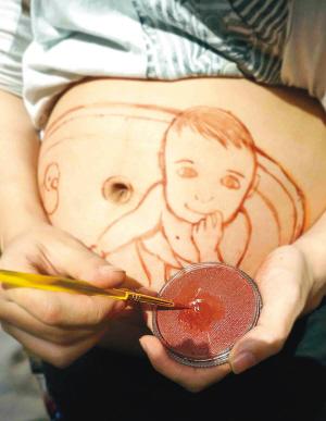 Luo paints on her belly. [Photo: Chengdu Evening News]