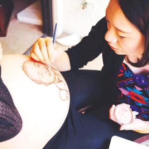 A friend invites Luo pains on her belly. [Photo: Chengdu Evening News]