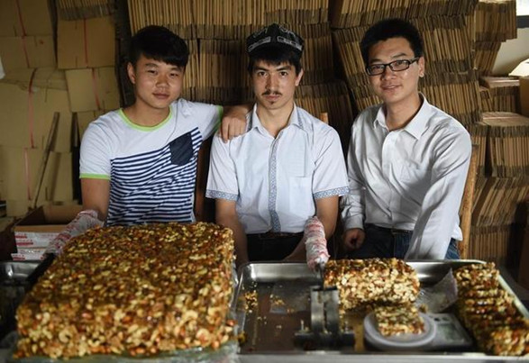 Group photo of Adili (C), Jiang Jinya (R), and Jiang Chunyang on May 22, 2014. (Xinhua/Li Ga)