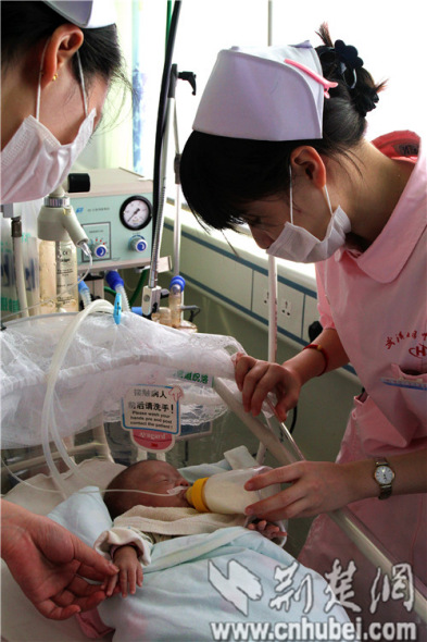 A medical staffer feeds a premature baby boy in a hospital of Wuhan who was delivered nine weeks early and weighed only 500g at birth on May 29, 2014. Thanks to the efforts of medical staff, the baby survives. He is over four months old, weighs about 2400 grams and is getting ready to go home. [Photo: cnhubei.com]