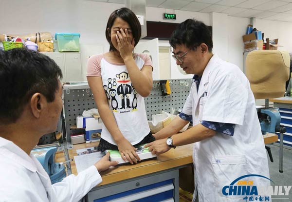 An artificial limb expert weighs Qian in Beijing, Aug 30, 2013. [Photo/chinadaily.com.cn]  