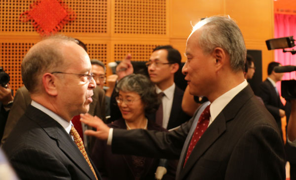 Chinese Ambassador to the US Cui Tiankai (right) and US Assistant Secretary of State for East Asian and Pacific Affairs Daniel Russel are in the media spotlight when they chat at a reception in the Chinese embassy in Washington on Monday evening to mark the 65th anniversary of the founding of the People's Republic of China. Chen Weihua/China Daily